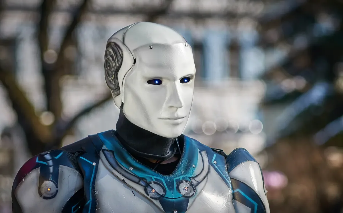 Close-up of a futuristic humanoid robot with metallic armor and blue LED eyes.